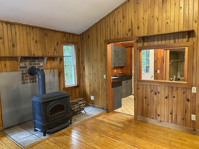 39 Salmon Rd, Madison, ME 04950 - unfurnished living room featuring hardwood / wood-style flooring, a wood stove, wooden walls, and vaulted ceiling