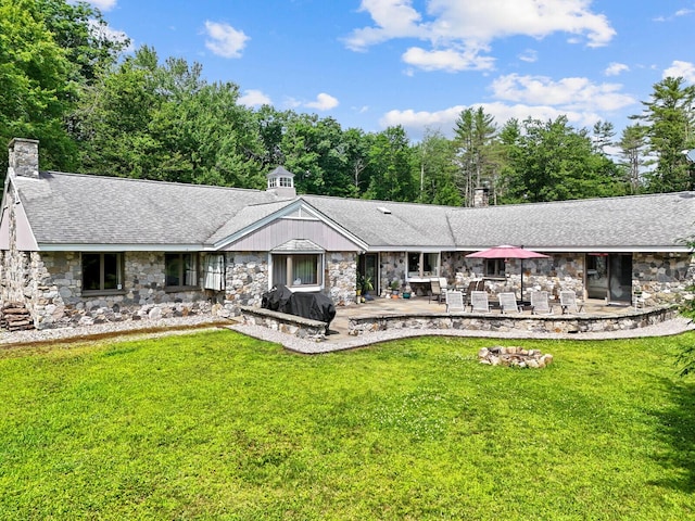 16 Davis Point Rd, Wayne, ME 04284 - view of front of home featuring stone siding, a chimney, a front lawn, a patio area, and a shingled roof