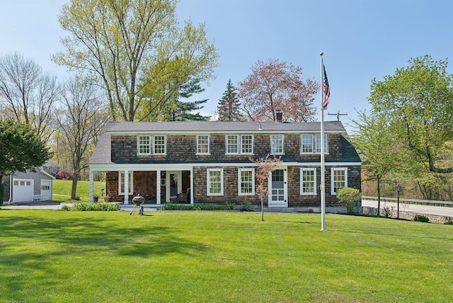 378 Pool St, Biddeford, ME 04005 - view of front of house featuring covered porch, a front yard, a detached garage, and an outbuilding