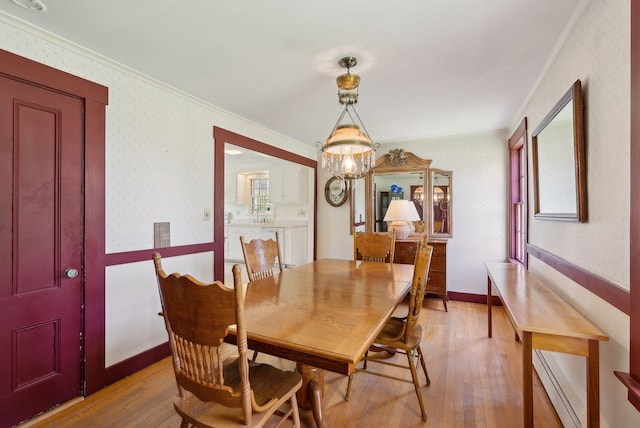 378 Pool St, Biddeford, ME 04005 - dining area featuring light wood finished floors, ornamental molding, wallpapered walls, a baseboard heating unit, and plenty of natural light