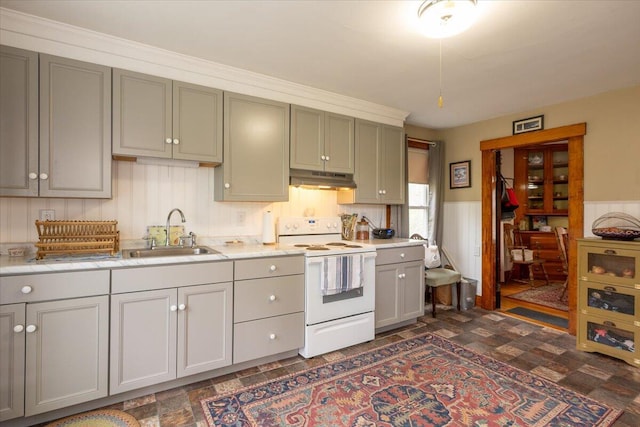 127 Harbor Rd, Friendship, ME 04547 - kitchen featuring white range with electric stovetop, a sink, under cabinet range hood, light countertops, and a wainscoted wall