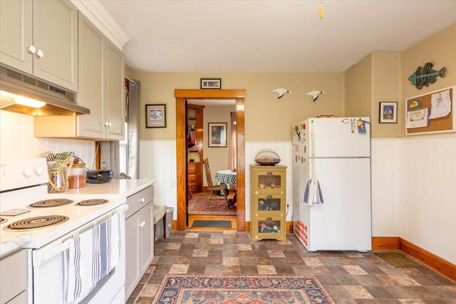 127 Harbor Rd, Friendship, ME 04547 - kitchen featuring white appliances, under cabinet range hood, wainscoting, light countertops, and stone finish floors