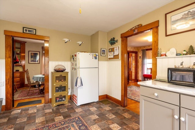 127 Harbor Rd, Friendship, ME 04547 - kitchen with freestanding refrigerator, a wainscoted wall, and light countertops
