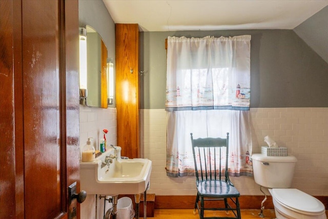127 Harbor Rd, Friendship, ME 04547 - half bathroom with tile walls, toilet, a wainscoted wall, and a sink