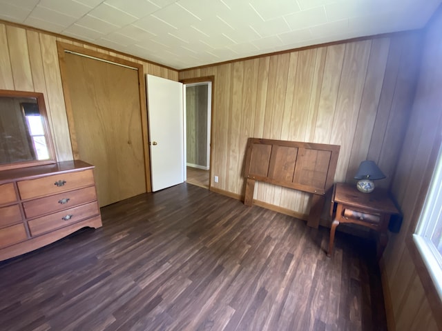 unfurnished bedroom featuring dark wood-style flooring and wood walls