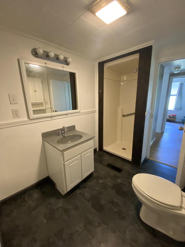 full bath featuring a shower stall, vanity, and toilet