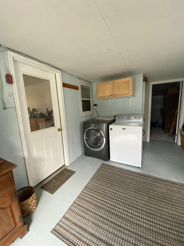 clothes washing area with independent washer and dryer and cabinet space