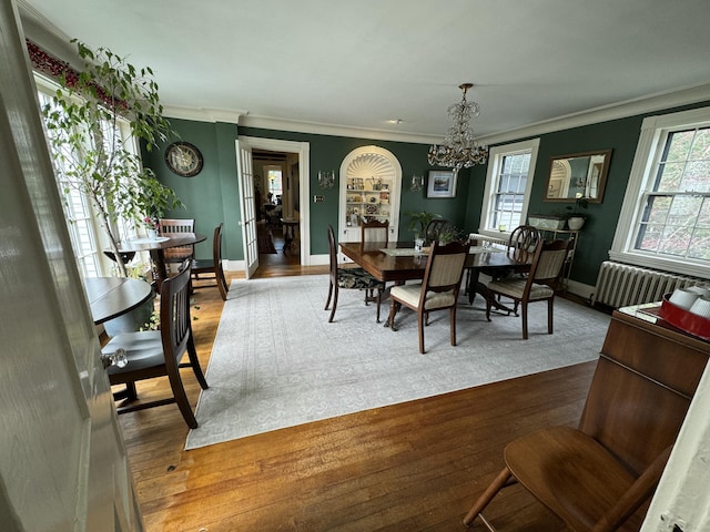 969 Washington St, Bath, ME 04530 - dining area with radiator heating unit, ornamental molding, plenty of natural light, a chandelier, and wood finished floors