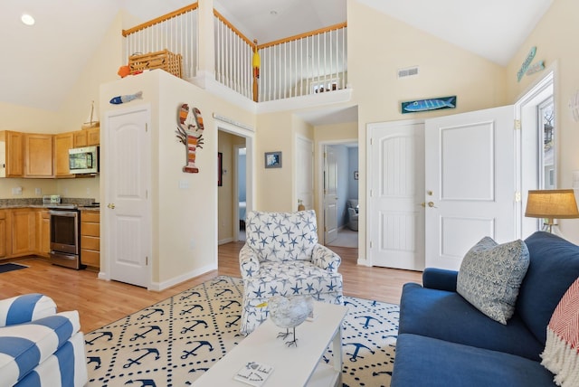 272 Mills Rd Unit 17, Kennebunkport, ME 04046 - living room with high vaulted ceiling, light wood-style floors, and baseboards