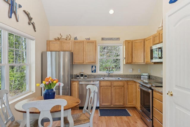 272 Mills Rd Unit 17, Kennebunkport, ME 04046 - kitchen with appliances with stainless steel finishes, a sink, light wood-style flooring, light stone countertops, and vaulted ceiling
