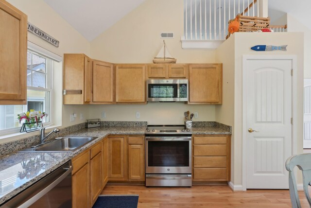 272 Mills Rd Unit 17, Kennebunkport, ME 04046 - kitchen with stainless steel appliances, a sink, light wood-type flooring, and high vaulted ceiling