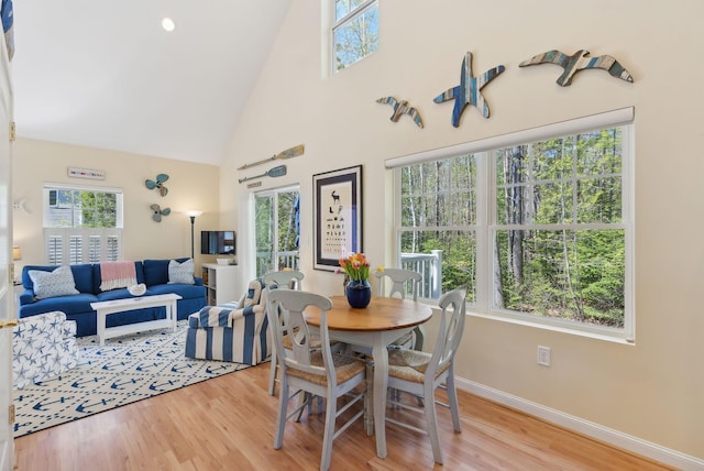 272 Mills Rd Unit 17, Kennebunkport, ME 04046 - dining space with high vaulted ceiling, baseboards, and light wood-type flooring