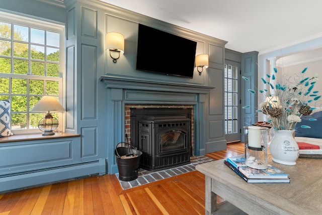 70 Summer St, Kennebunk, ME 04043 - living area featuring ornamental molding, a baseboard heating unit, wood-type flooring, healthy amount of natural light, and a decorative wall
