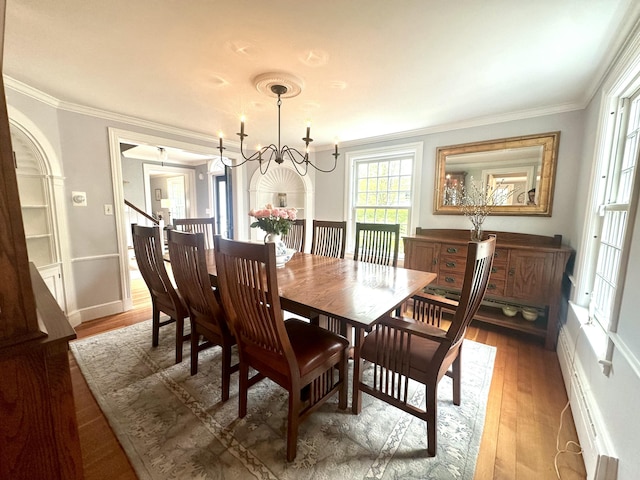 70 Summer St, Kennebunk, ME 04043 - dining room featuring crown molding, a chandelier, wood finished floors, baseboards, and a baseboard heating unit