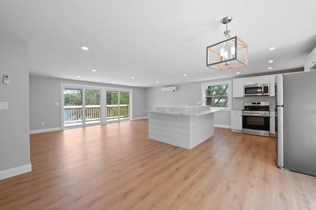 347 Brownfield Rd, Porter, ME 04068 - kitchen with appliances with stainless steel finishes, a wall unit AC, light wood-style flooring, recessed lighting, and white cabinets
