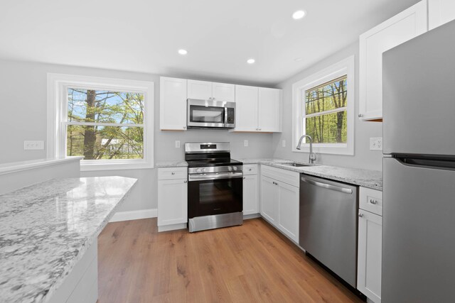347 Brownfield Rd, Porter, ME 04068 - kitchen with stainless steel appliances, a sink, light wood-style floors, white cabinets, and recessed lighting