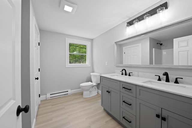 347 Brownfield Rd, Porter, ME 04068 - full bath with a baseboard radiator, baseboards, toilet, wood finished floors, and double vanity
