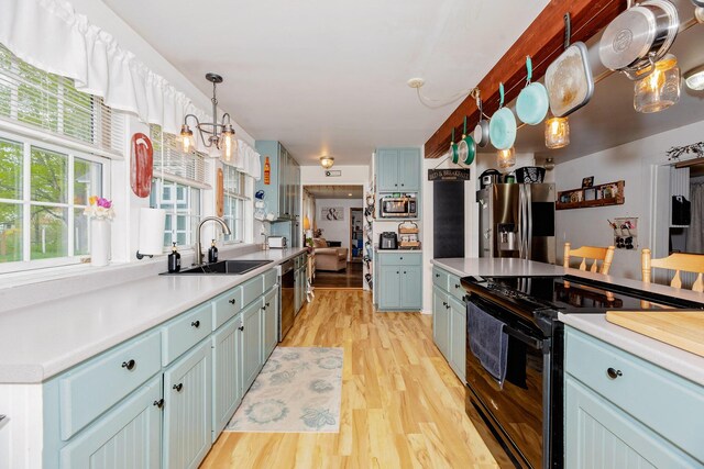 22 Pleasant St, Phillips, ME 04966 - kitchen with appliances with stainless steel finishes, a sink, blue cabinetry, and light wood finished floors