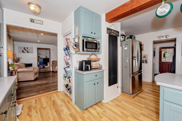 22 Pleasant St, Phillips, ME 04966 - kitchen featuring appliances with stainless steel finishes, blue cabinetry, light wood finished floors, light countertops, and beam ceiling