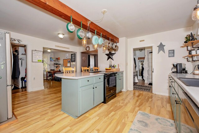 22 Pleasant St, Phillips, ME 04966 - kitchen featuring black electric range oven, a peninsula, light wood-style floors, light countertops, and blue cabinets