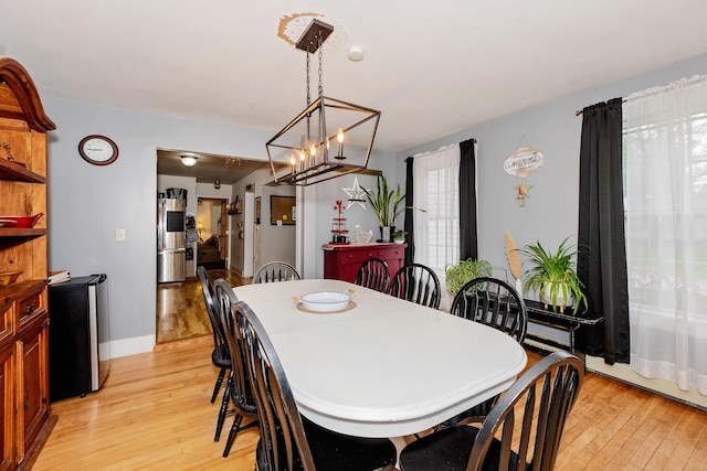 22 Pleasant St, Phillips, ME 04966 - dining area featuring light wood finished floors, a chandelier, and baseboards