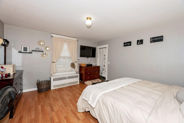 22 Pleasant St, Phillips, ME 04966 - bedroom featuring radiator heating unit, wood finished floors, and baseboards