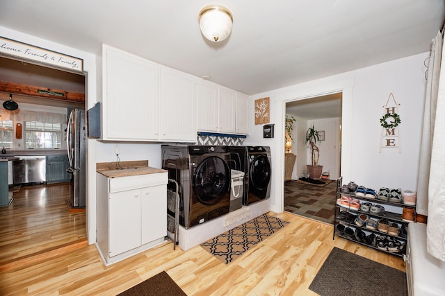 22 Pleasant St, Phillips, ME 04966 - laundry area featuring washing machine and clothes dryer, cabinet space, and light wood-type flooring