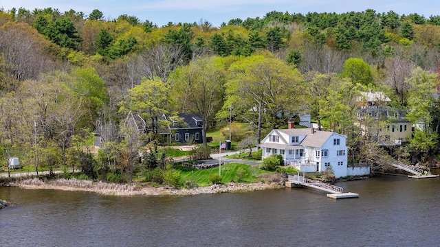 view from above of property featuring a nearby body of water and a forest