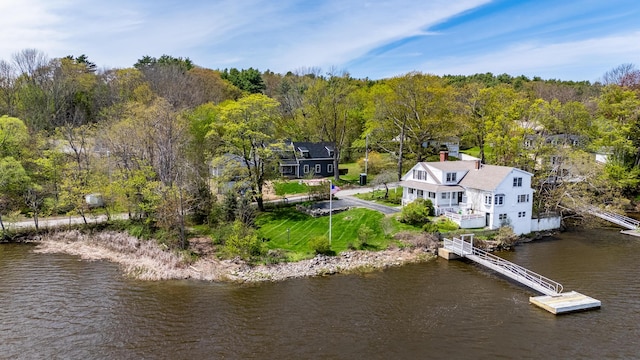 view of subject property with a nearby body of water and a forest