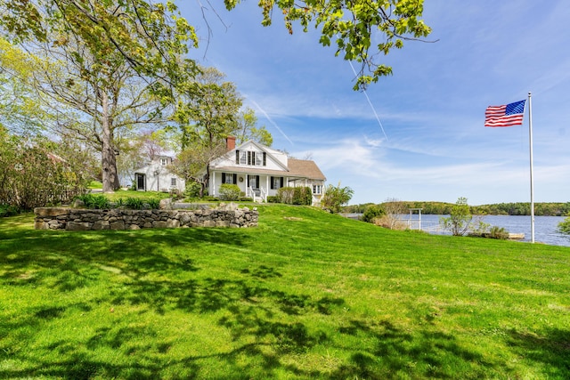 view of green lawn featuring a water view