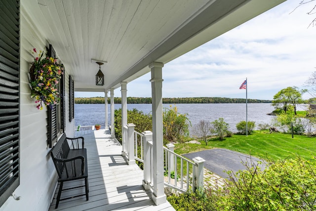 wooden deck featuring a water view and a yard