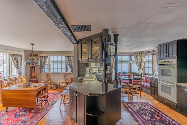 kitchen featuring white double oven, hardwood / wood-style flooring, and decorative light fixtures