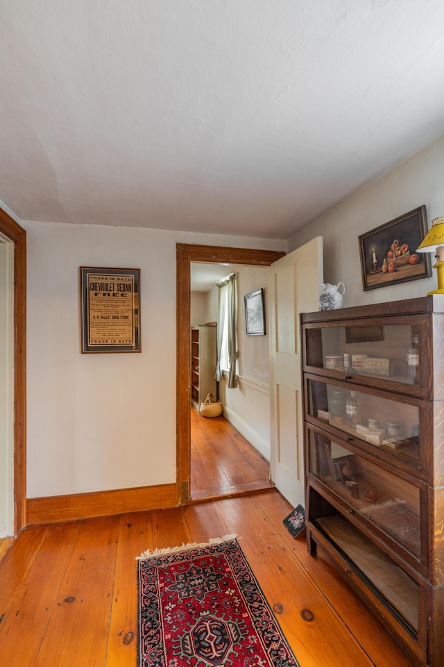 hall with hardwood / wood-style floors and baseboards