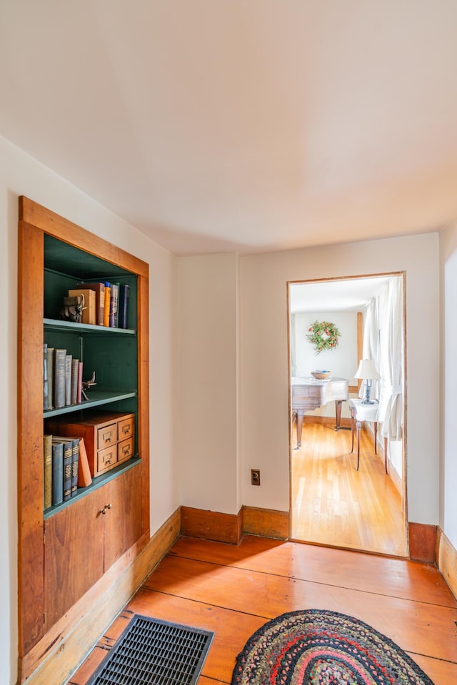 hallway featuring hardwood / wood-style floors and baseboards