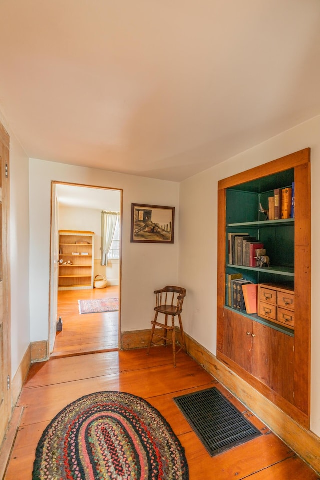 corridor with light wood finished floors and baseboards