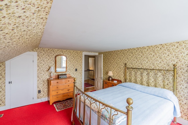 bedroom with vaulted ceiling and wallpapered walls