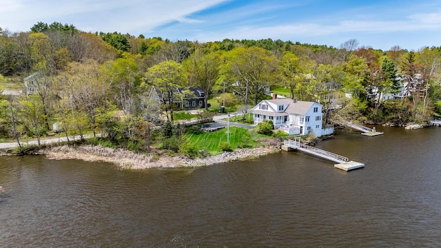 view of subject property with a large body of water and a forest