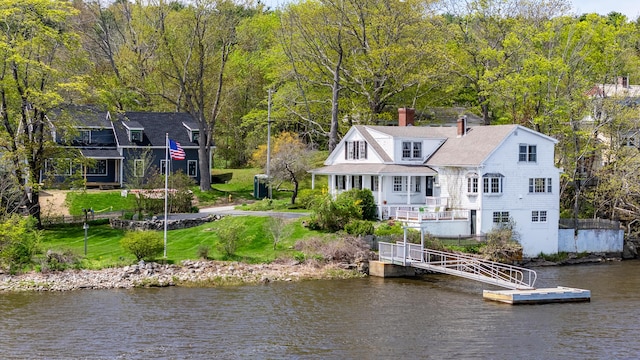 rear view of house with a chimney and a water view