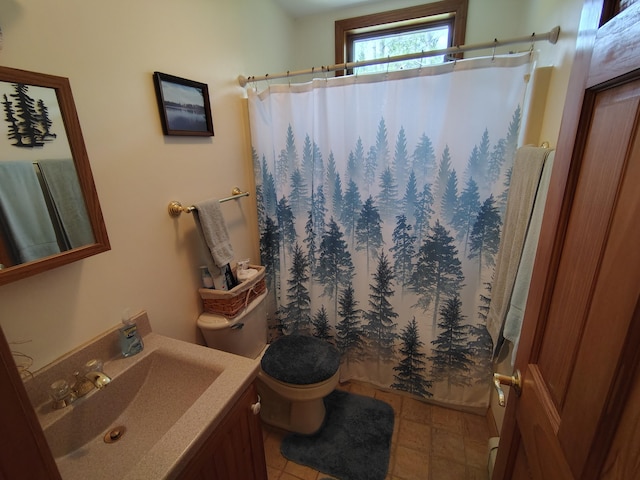 bathroom featuring toilet, curtained shower, vanity, and tile patterned floors