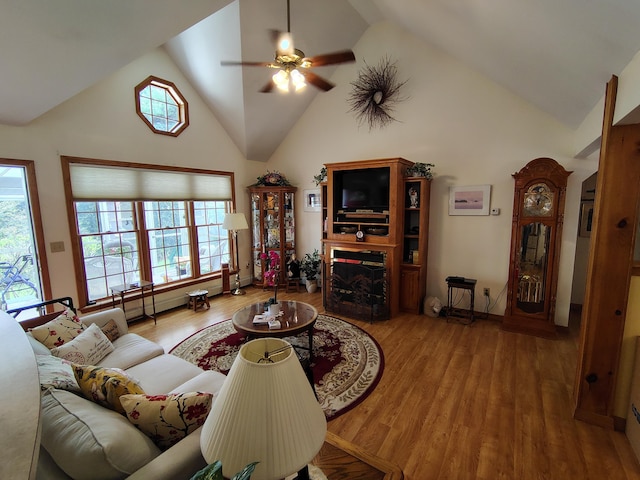 living area with a ceiling fan, high vaulted ceiling, and wood finished floors