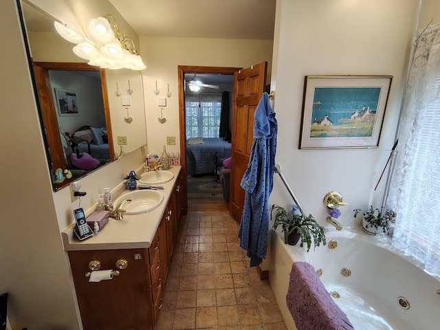 bathroom featuring ensuite bathroom, vanity, a whirlpool tub, and stone tile floors