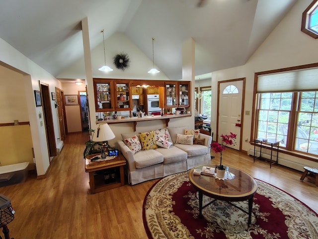 living area with light wood finished floors and high vaulted ceiling