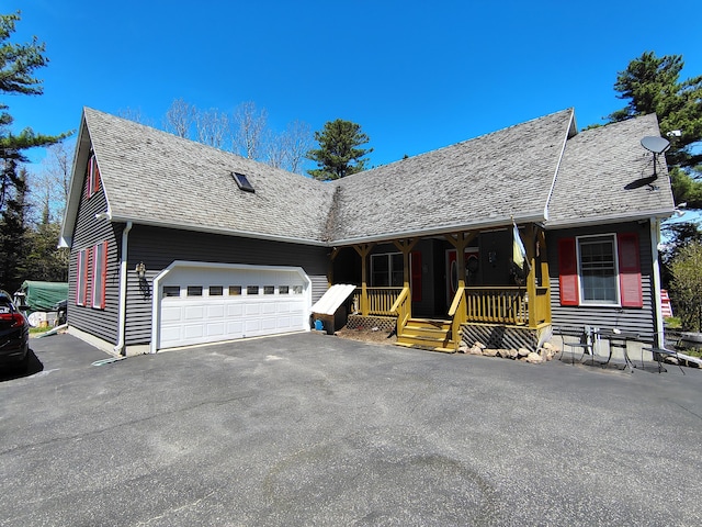 view of front of home with driveway, covered porch, a shingled roof, and an attached garage