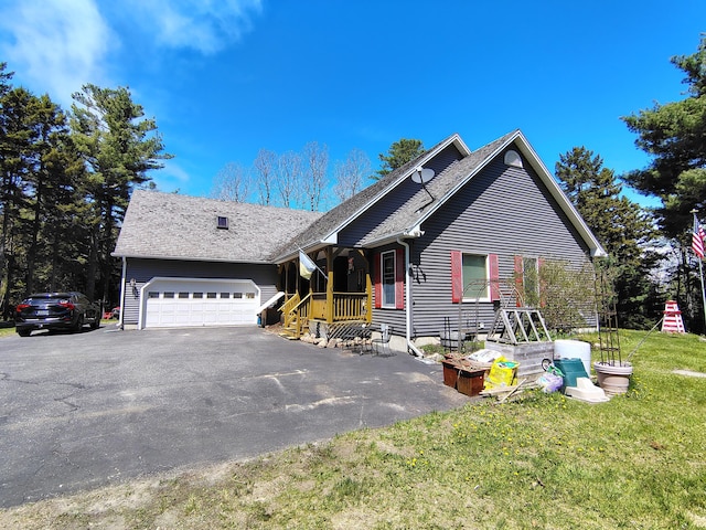 view of front of home with a garage, asphalt driveway, and a front yard