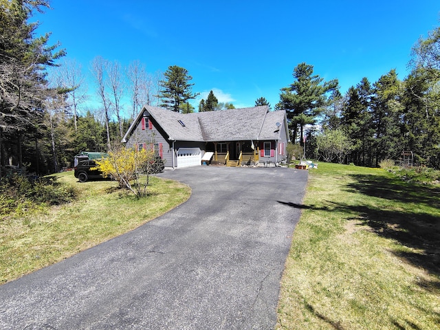 view of front of home with a garage, a front lawn, and driveway
