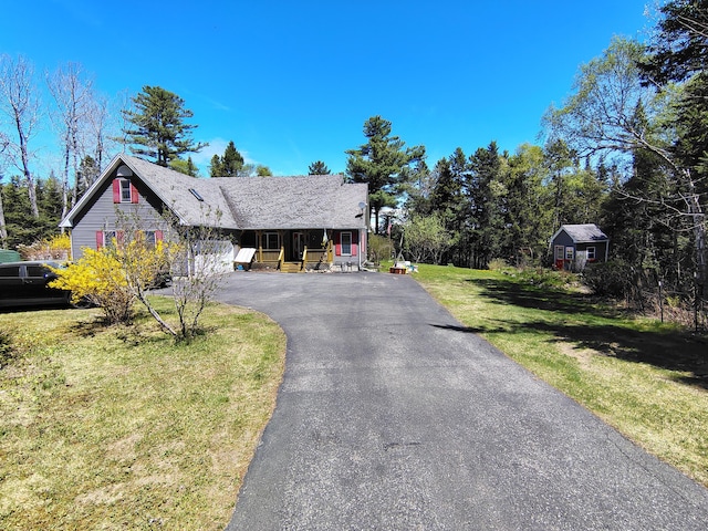 view of front of home with a front lawn, asphalt driveway, and covered porch