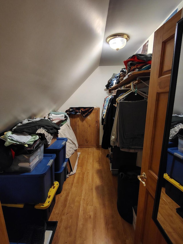 spacious closet with light wood-style flooring and lofted ceiling