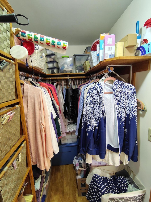 walk in closet with wood finished floors