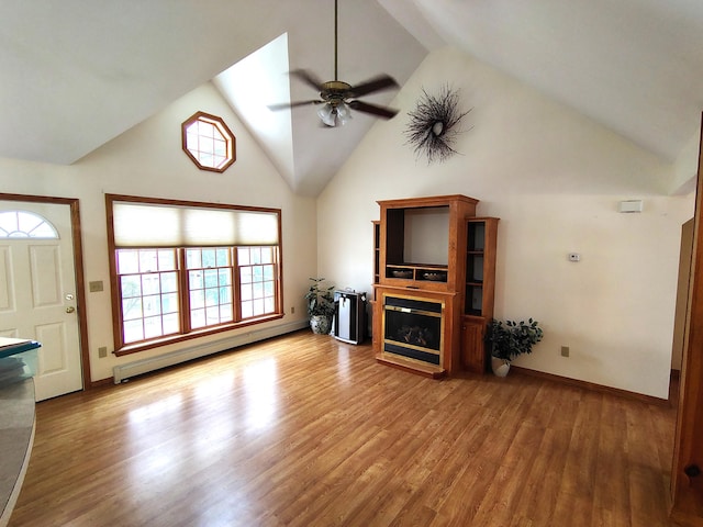 100 Weber Ln, Calais, ME 04619 - unfurnished living room with a baseboard radiator, high vaulted ceiling, ceiling fan, wood finished floors, and a glass covered fireplace