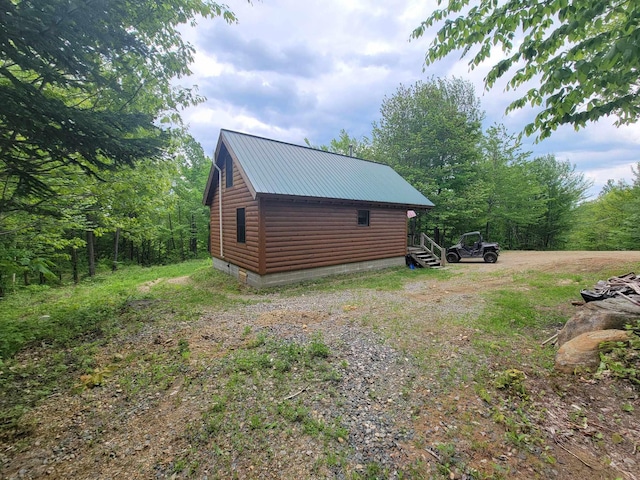 233 Weld Rd, Phillips, ME 04966 - view of side of property with log veneer siding and metal roof